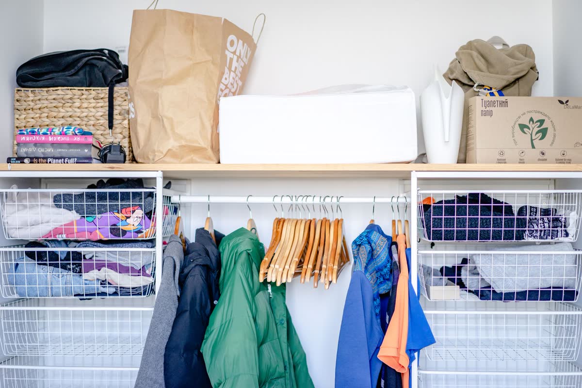 A small closet organized with a wire shelf system and bins