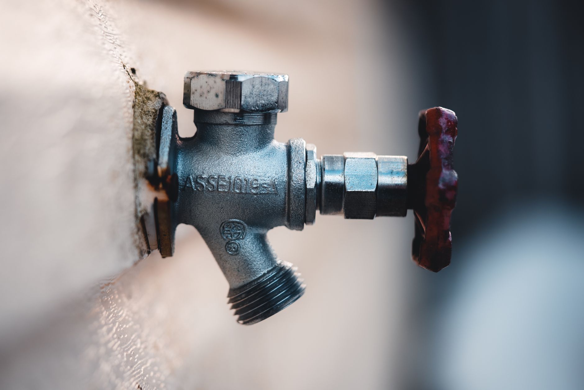 An outdoor faucet on the side of a house
