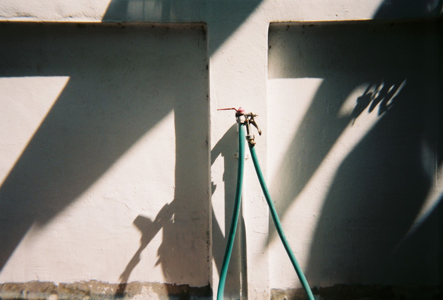 A garden hose connected to an outdoor spigot