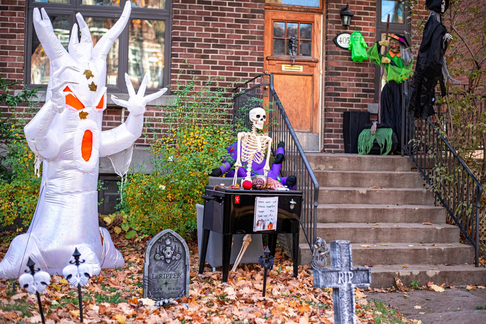 Inflatable ghost and posed skeleton on a decorated lawn