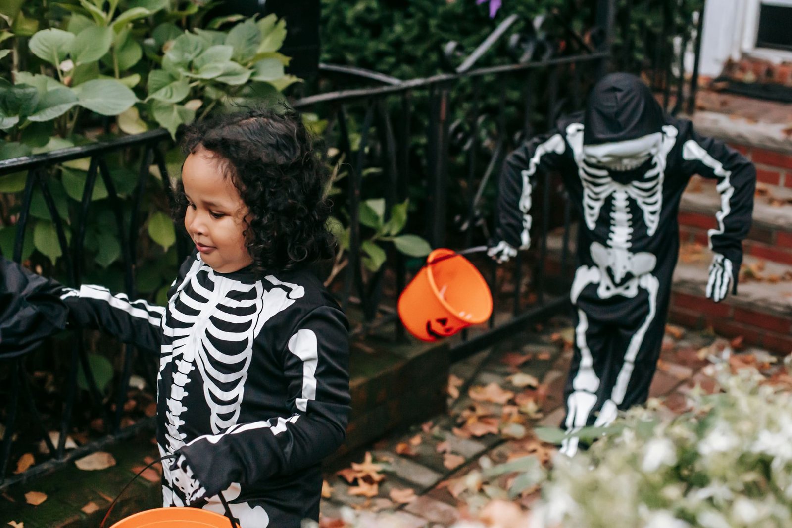 Kids in glow-in-the-dark skeleton costumes at night