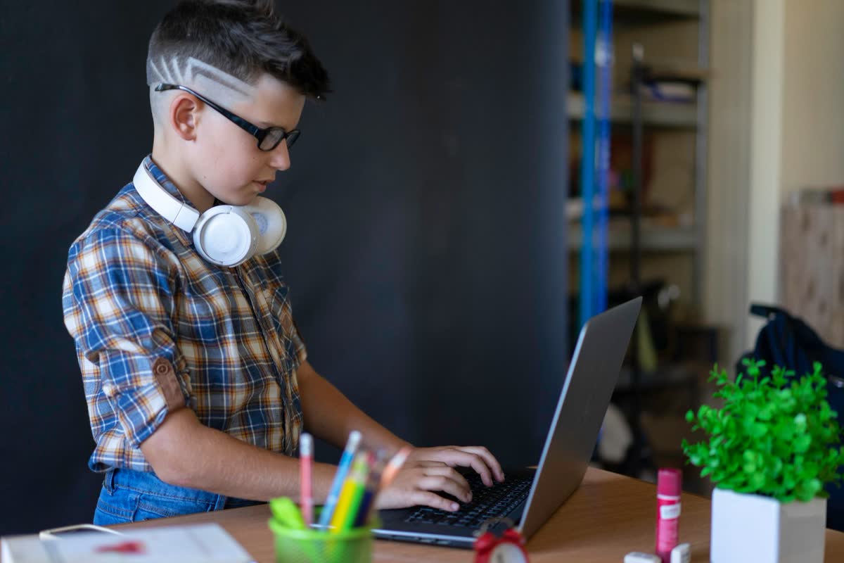 A student using a laptop with headphones